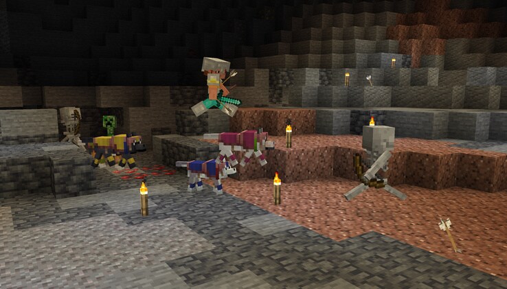 Ari is fighting two Skeletons and a Creeper in a partially lit cave with their Tamed Wolves who are wearing colorful Wolf Armor sets.